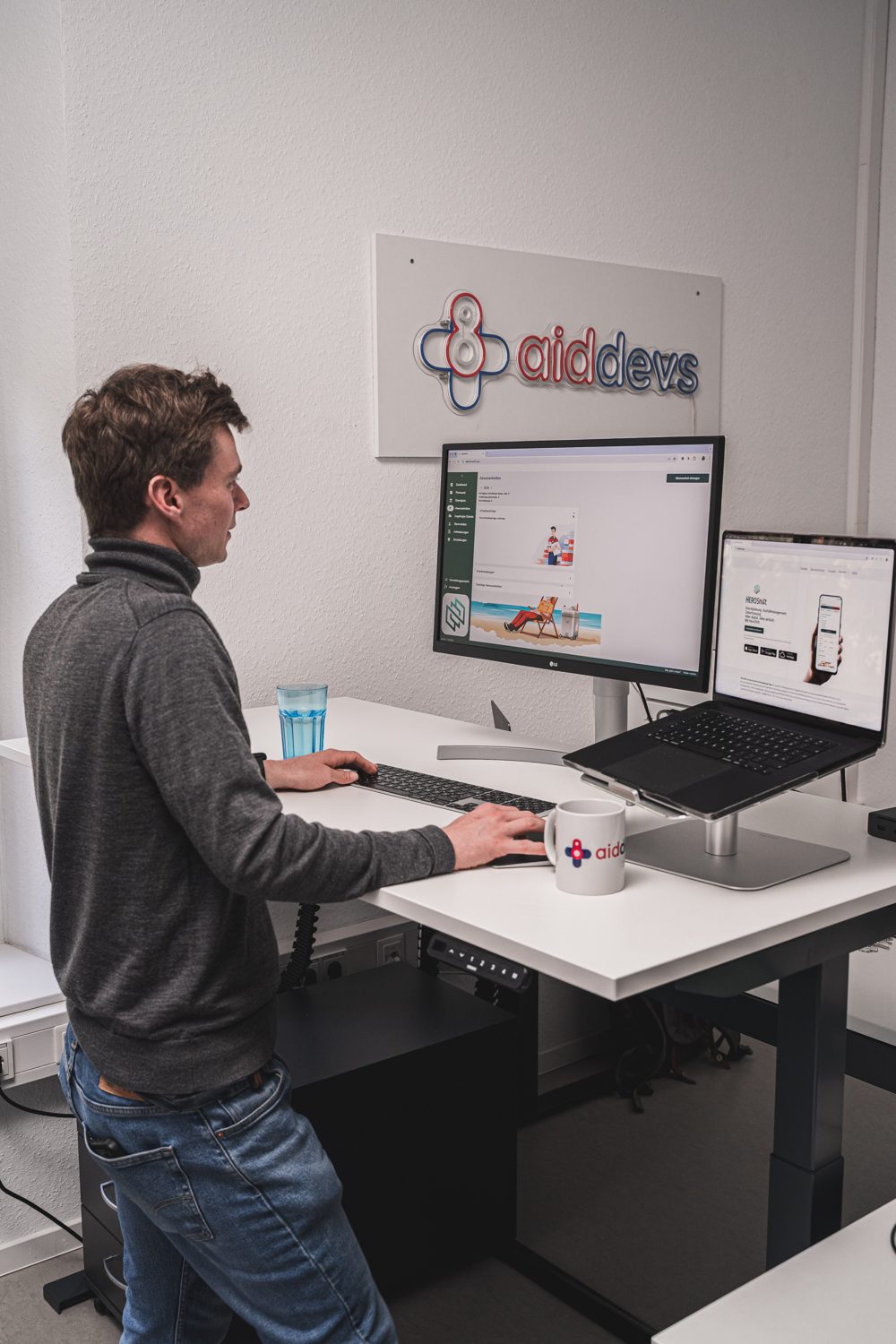 Jonas Deichelmann arbeitet im Stehen am Schreibtisch im aiddevs Büro