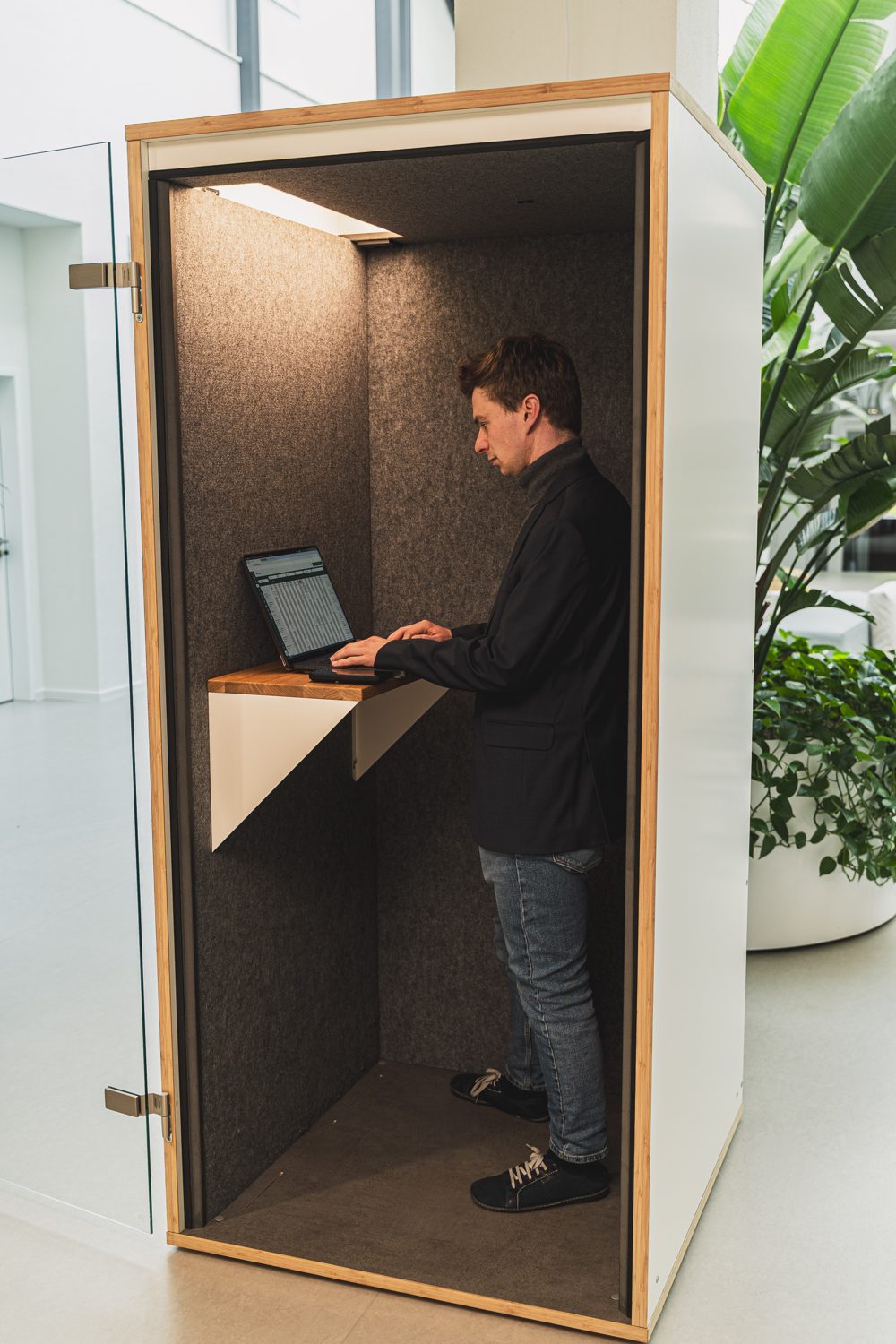 Jonas Deichelmann in einer Telefonbox am Laptop